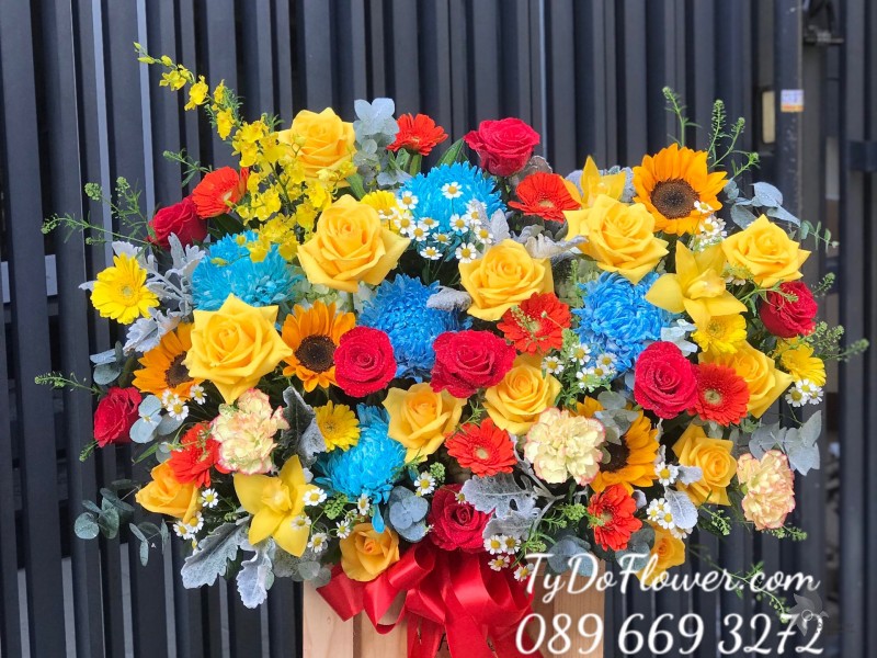 G122211 GIỎ HOA CHÚC MỪNG thiết kế hoa Cúc Mẫu Đơn xanh dương, hoa hồng đỏ-vàng, hoa hướng dương, đồng tiền cam-vàng, cẩm chướng, cúc tana, lá bạc