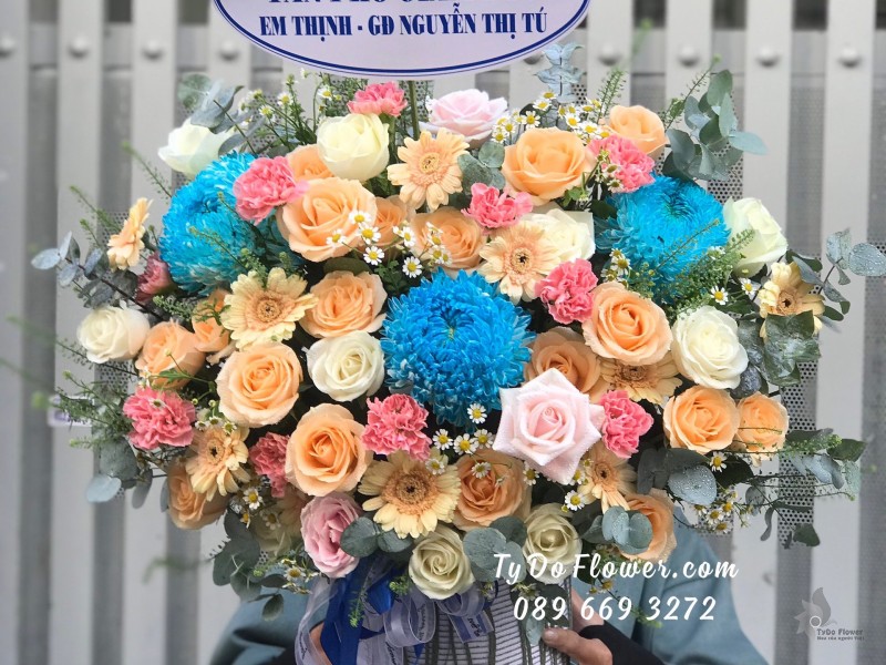 G0623812 GIỎ HOA CHÚC MỪNG TÂN PHÓ GIÁM ĐỐC thiết kế Cúc Mẫu Đơn xanh dương, hoa hồng cam-trắng, đồng tiền cam, cẩm chướng hồng, cúc tana, cỏ đồng tiền, lá bạc