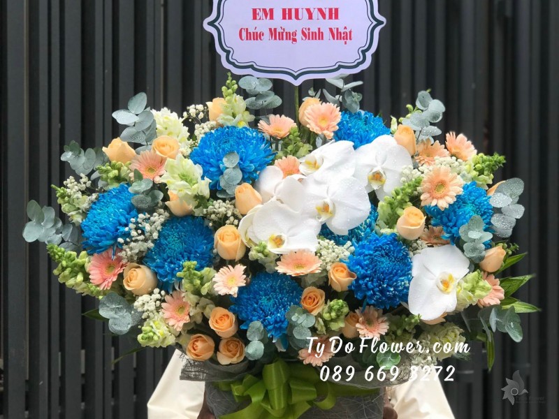 G09231012 GIỎ HOA CHÚC MỪNG SINH NHẬT thiết kế hoa Cúc Xanh Dương, Hoa Hồng Cam, Đồng Tiền Mini Cam, Lan Hồ Điệp Trắng, Mõm Sói Trắng