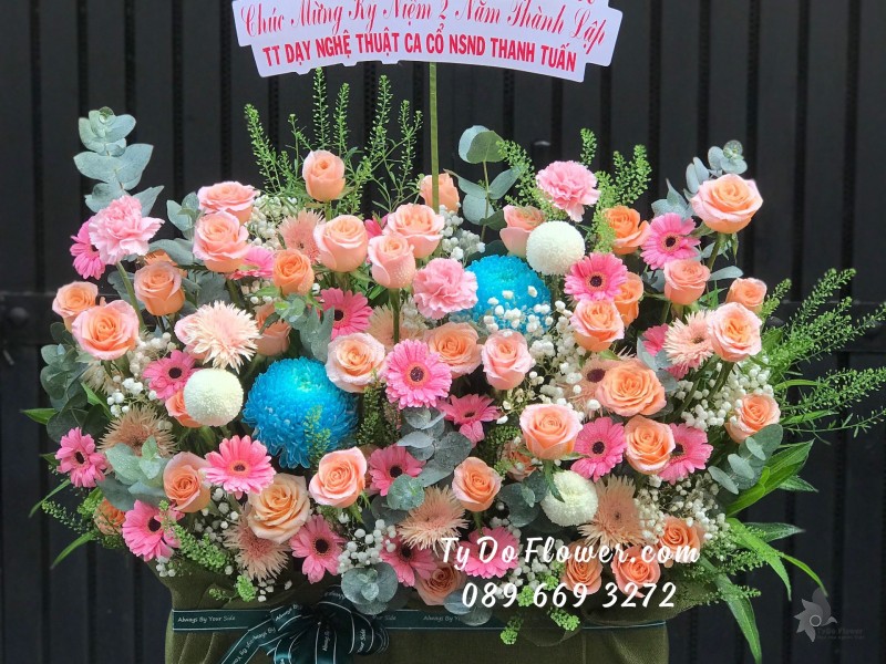 G04241483 GIỎ HOA CHÚC MỪNG KỶ NIỆM THÀNH LẬP thiết kế tone màu hồng cam, chủ đạo Hoa Hồng Cam Carrot, Đồng Tiền Mini Hồng, điểm nhấn Hoa Cúc Mẫu Đơn Xanh Dương