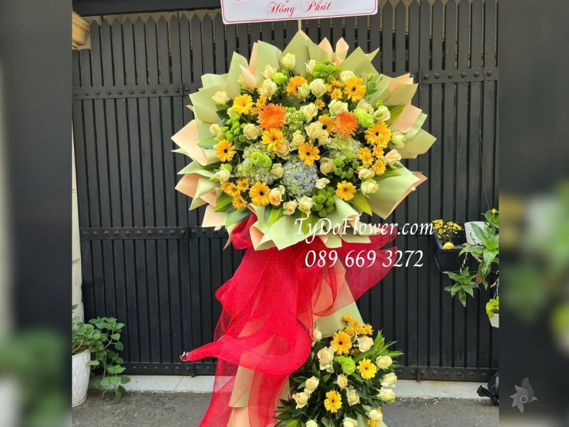 KCM01255 KỆ HOA CHÚC MỪNG KHAI TRƯƠNG HỒNG PHÁT Thiết kế tông màu vàng xanh cốm , chủ đạo Hoa Đồng Tiền, Cẩm Tú Cầu, Hoa Hồng Cam Trứng
