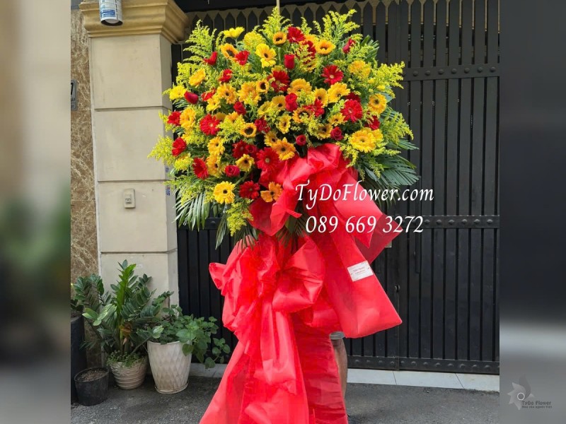 KCM012510 KỆ HOA CHÚC MỪNG Thiết kế tông màu đỏ vàng, chủ đạo Hoa Đồng Tiền