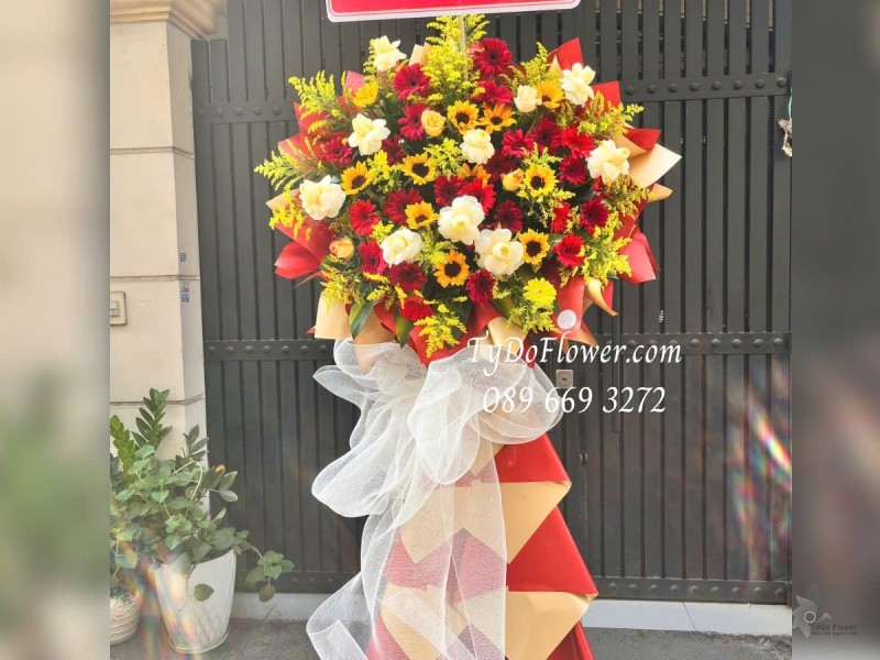 KCM012513 KỆ HOA CHÚC MỪNG Thiết kế tông màu đỏ vàng, chủ đạo Hoa Hồng Vàng Victor, Hướng Dương, Đồng Tiền