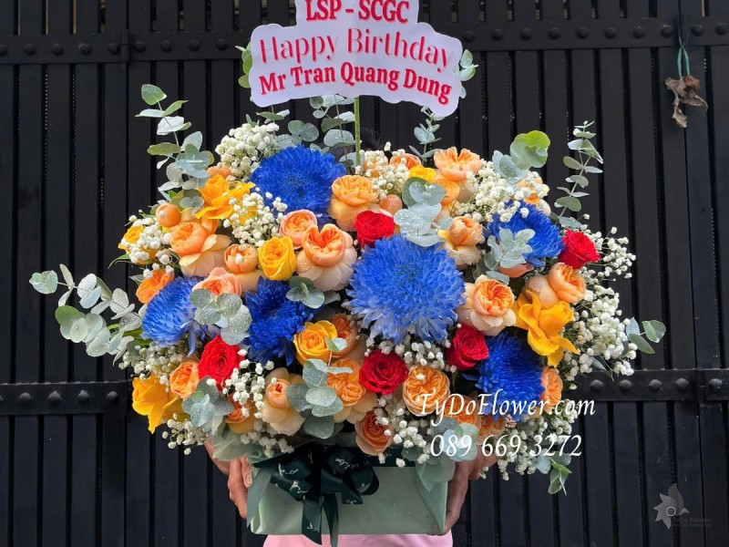 G012579 GIỎ HOA CHÚC MỪNG SINH NHẬT Thiết kế tông màu cam xanh dương, chủ đạo Hoa Cúc Xanh, Hoa Hồng Cam Juliet
