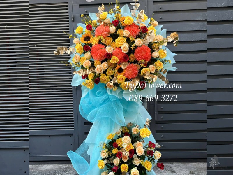 KCM0325193 KỆ HOA CHÚC MỪNG KHAI TRƯƠNG Thiết kế gam màu vàng cam, chủ đạo Hoa Hồng Vàng Cam, Cúc Mẫu Đơn Cam