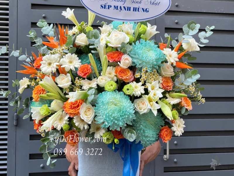 G0525395 GIỎ HOA CHÚC MỪNG SINH NHẬT Thiết kế Hoa Hồng Cam Spirit, Hoa Hồng Trắng, Hoa Lily, Đồng Tiền, Cát Tường Xanh. Cúc Xanh, Thiên Điểu