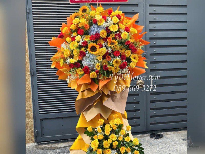 KCM0525400 KỆ HOA CHÚC MỪNG ĐẠI LỄ PHẬT ĐẢN Thiết kế gam màu đỏ vàng, Hoa Hồng, Đồng Tiền, Hướng Dương, Cẩm Tú Cầu