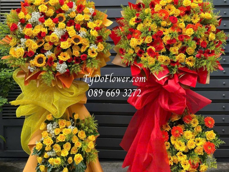 KCM0725509 MỘT CẶP KỆ HOA CHÚC MỪNG Thiết kế gam màu đỏ vàng cam, chủ đạo hoa hồng, đồng tiền