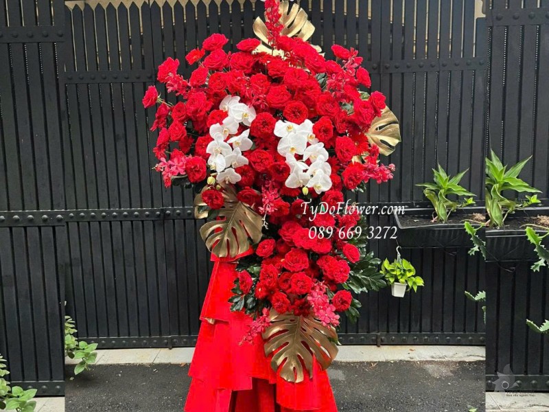 KCM0825618 KỆ HOA CHÚC MỪNG KHAI TRƯƠNG HỒNG PHÁT Thiết kế hoa hồng đỏ Ohara Red Rose, Lan Hồ Điệp, Lá Trầu Bà Nam Mỹ
