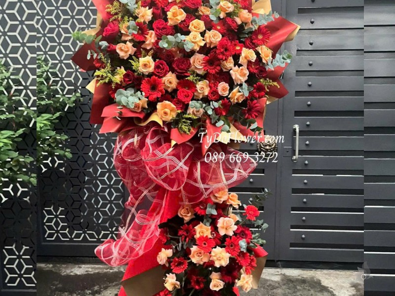 KCM0825622 KỆ HOA CHÚC MỪNG Thiết kế hoa hồng đỏ cam, đồng tiền đỏ, nền giấy mỹ thuật cao cấp