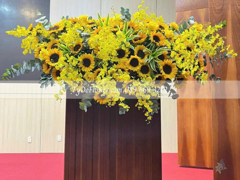 L0825639 HOA TRANG TRÍ BỤC PHÁT BIỂU Thiết kế Hoa Hướng Dương, Hoa Lan Vũ Nữ