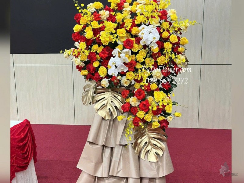 KCM0825643 KỆ HOA CHÚC MỪNG Thiết kế hoa hồng đỏ vàng, lan vũ nữ, lan hồ điệp, chân giấy mỹ thuật cao cấp