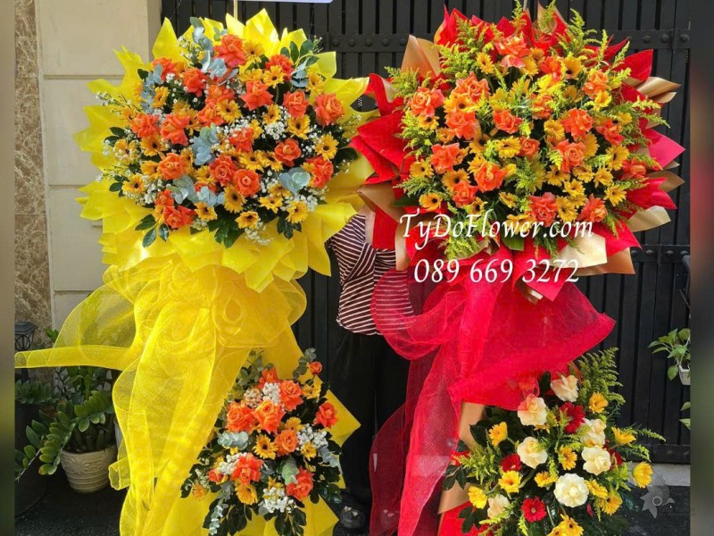 KCM0126029 ĐẶT TỪ 02 KỆ HOA CHÚC MỪNG Thiết kế hoa hồng cam, đồng tiền vàng