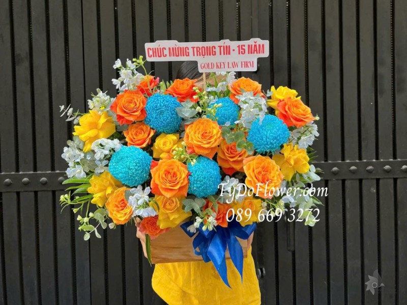 G0226106 GIỎ HOA CHÚC MỪNG 15 NĂM THÀNH LẬP Thiết kế tông màu cam xanh dương, hoa hồng vàng cam, cúc mẫu đơn xanh dương