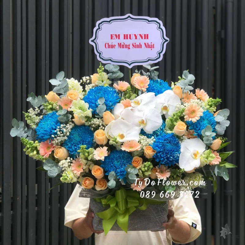G09231012 GIỎ HOA CHÚC MỪNG SINH NHẬT thiết kế hoa Cúc Xanh Dương, Hoa Hồng Cam, Đồng Tiền Mini Cam, Lan Hồ Điệp Trắng, Mõm Sói Trắng