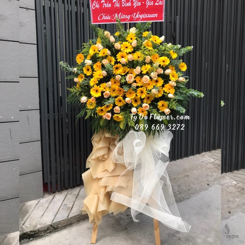 KCM01241257 KỆ HOA CHÚC MỪNG thiết kế tone vàng chủ đạo Hoa Đồng Tiền Vàng, Hoa Hồng Cam Trứng