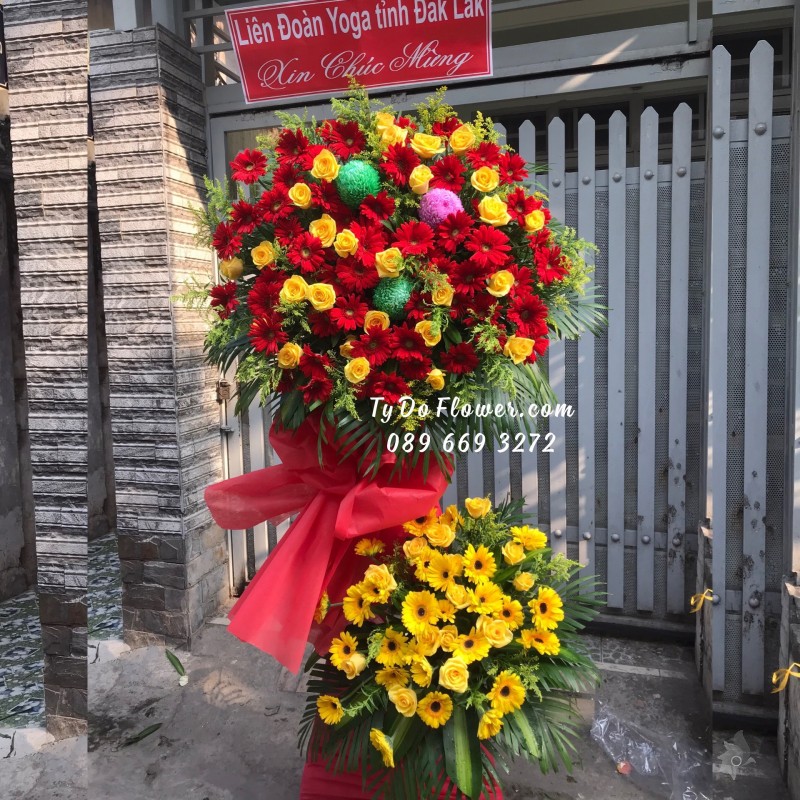 KCM01241260 KỆ HOA CHÚC MỪNG thiết kế tone màu đỏ-vàng chủ đạo Hoa Hồng Vàng, Đồng Tiền Đỏ, điểm nhấn Cúc Mẫu Đơn Xanh-Hồng