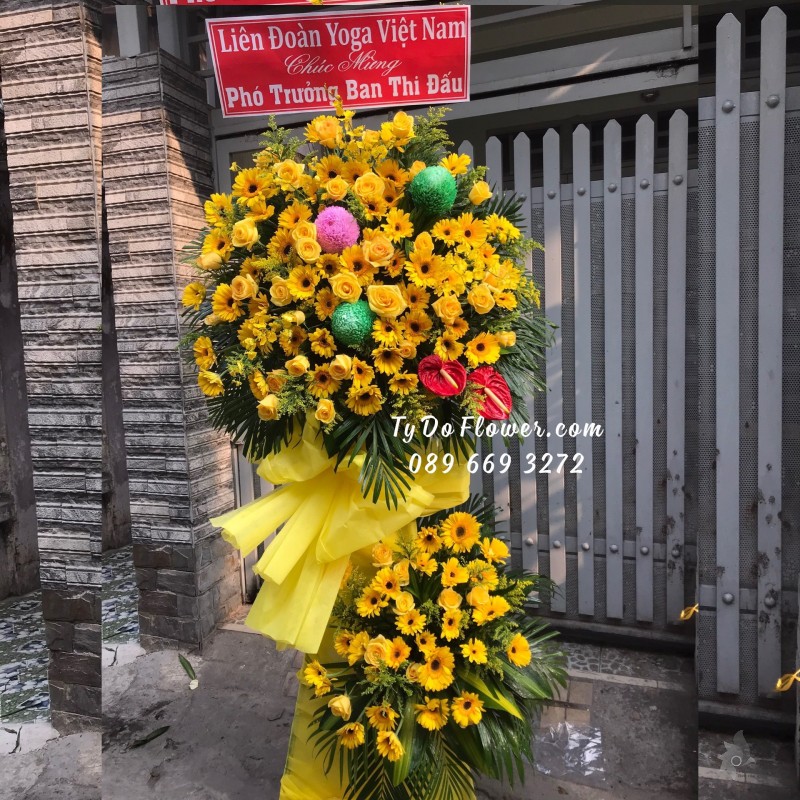 KCM01241262 KỆ HOA CHÚC MỪNG thiết kế tone màu vàng chủ đạo Hoa Hồng Vàng, Đồng Tiền Vàng, điểm nhấn Cúc Mẫu Đơn Xanh-Hồng