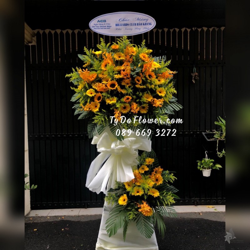 KCM07241731 KỆ HOA CHÚC MỪNG KHAI TRƯƠNG thiết kế Hoa Hướng Dương, Đồng Tiền Vàng, Lan Vàng Mokara