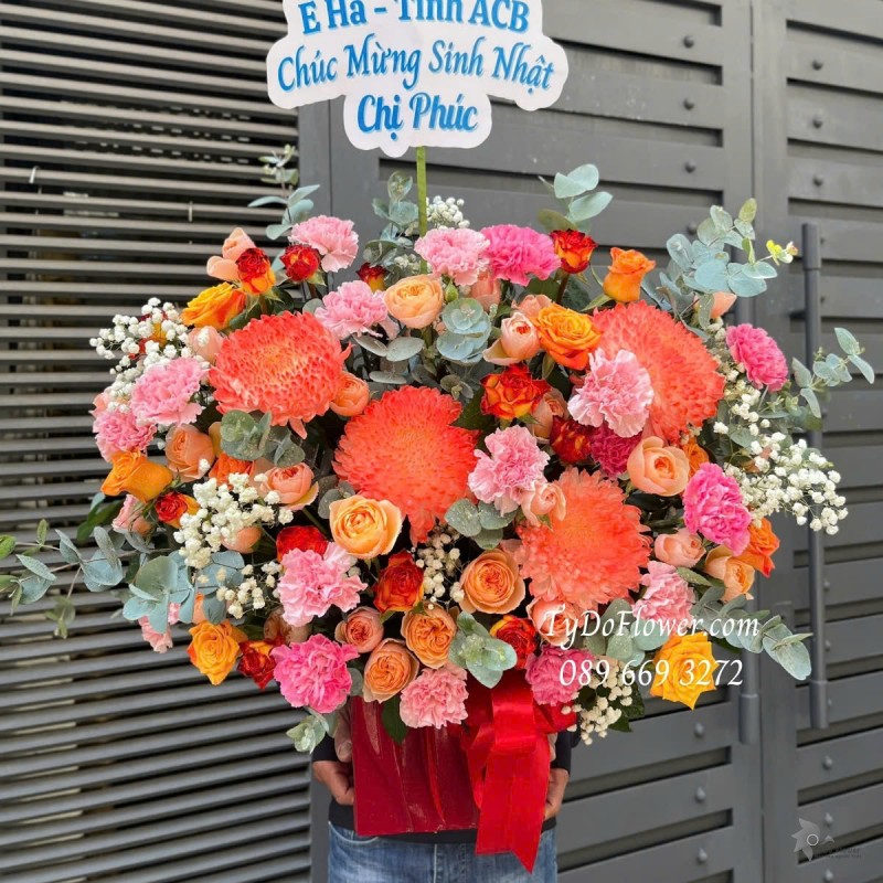 G012564 GIỎ HOA CHÚC MỪNG SINH NHẬT Thiết kế tông màu hồng cam, chủ đạp hoa hồng cam, hoa cúc mẫu đơn cam, cẩm chướng phăng hồng