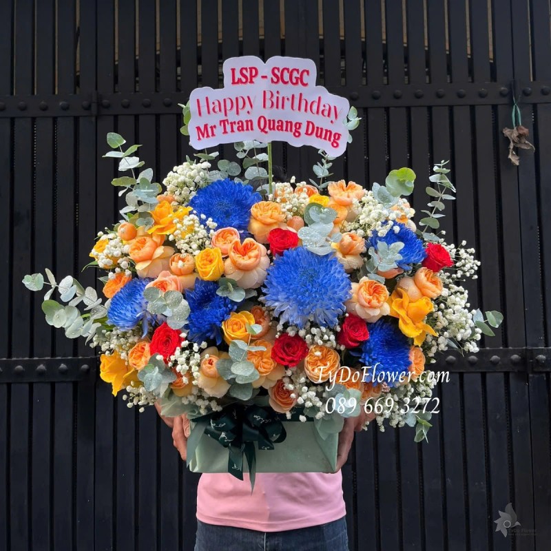G012579 GIỎ HOA CHÚC MỪNG SINH NHẬT Thiết kế tông màu cam xanh dương, chủ đạo Hoa Cúc Xanh, Hoa Hồng Cam Juliet