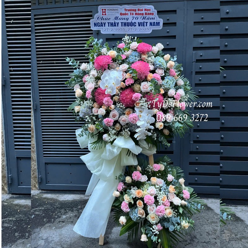 KCM0125168 KỆ HOA CHÚC MỪNG NGÀY THẦY THUỐC VN Thiết kế tông màu hồng, chủ đạo Hoa Cúc Mẫu Đơn Hồng, Hoa Hồng Hồng Cam, Cẩm Chướng Phăng Hồng, Tú Cầu