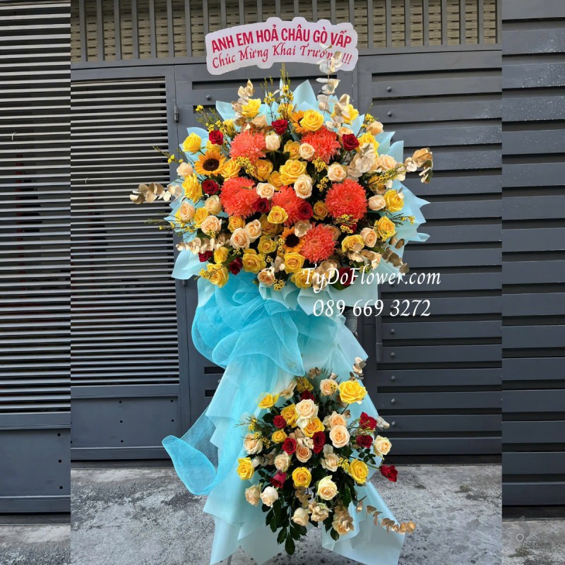 KCM0325193 KỆ HOA CHÚC MỪNG KHAI TRƯƠNG Thiết kế gam màu vàng cam, chủ đạo Hoa Hồng Vàng Cam, Cúc Mẫu Đơn Cam