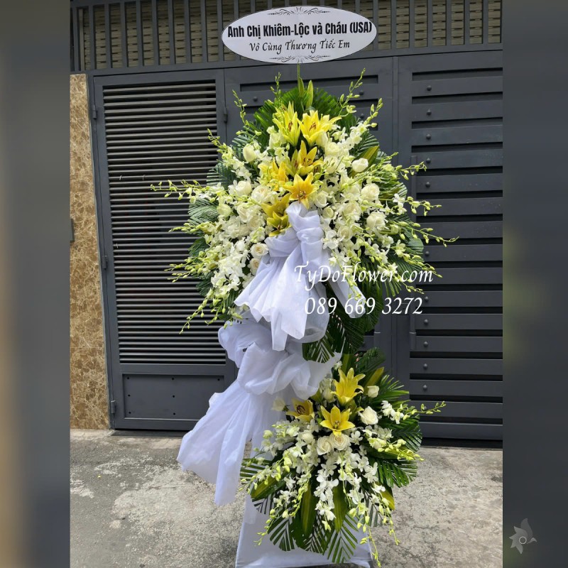 KCB0325240 KỆ HOA TANG LỄ VÒNG HOA CHIA BUỒN Vô Cùng Thương Tiếc Thiết kế 02 tầng Hoa Lan Trắng, Ly Vàng, Hồng Trắng