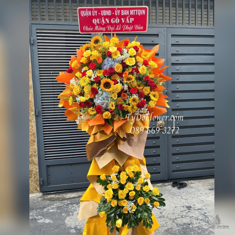 KCM0525400 KỆ HOA CHÚC MỪNG ĐẠI LỄ PHẬT ĐẢN Thiết kế gam màu đỏ vàng, Hoa Hồng, Đồng Tiền, Hướng Dương, Cẩm Tú Cầu