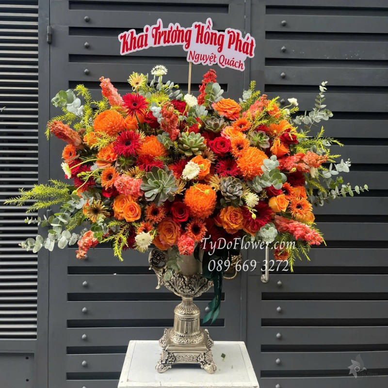 BI0525420 BÌNH HOA CAO CẤP Chúc Mừng Khai Trương Hồng Phát Thiết kế gam màu Đỏ Cam, chủ đạo Hoa Hồng Đỏ Ecuador, Hoa Hồng Cam Spirit, Cúc Mẫu Đơn Cam, Đồng Tiền Tua