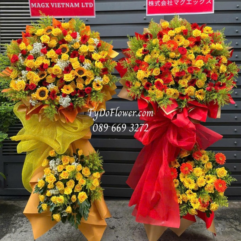 KCM0725509 MỘT CẶP KỆ HOA CHÚC MỪNG Thiết kế gam màu đỏ vàng cam, chủ đạo hoa hồng, đồng tiền