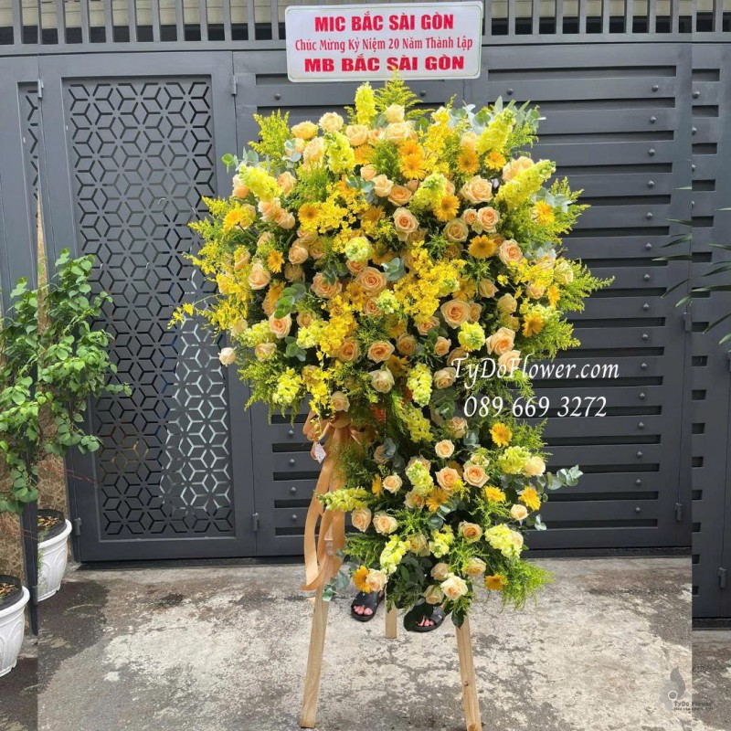 KCM0825614 KỆ HOA CHÚC MỪNG Thiết kế gam màu vàng cam, chủ đạo hoa hồng cam, lan vũ nữ, mõm sói vàng