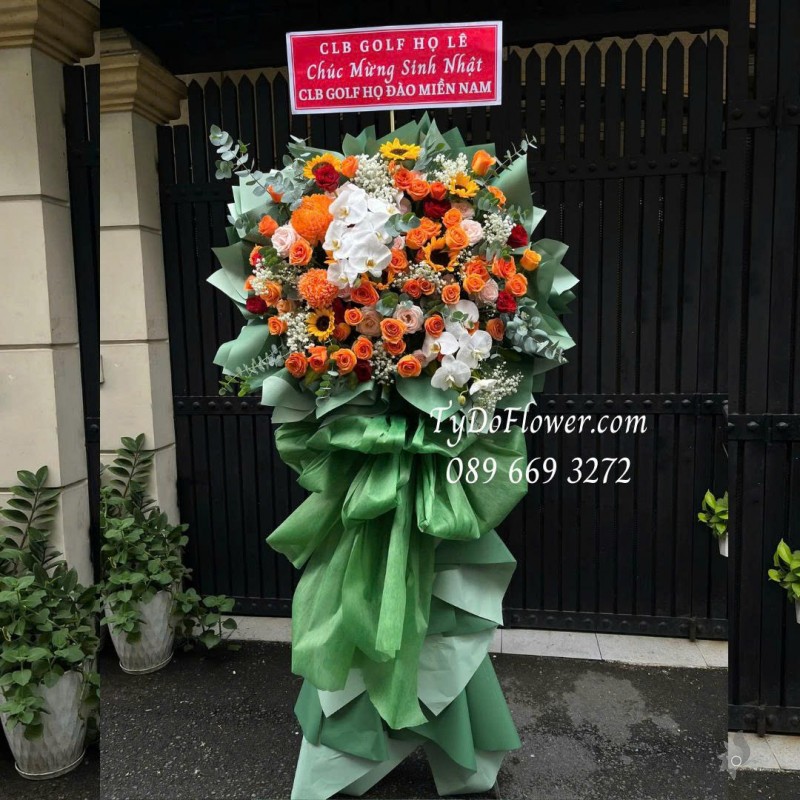 KCM0825621 KỆ HOA CHÚC MỪNG SINH NHẬT Thiết kế gam màu cam, hoa hồng cam sprit, cúc mẫu đơn cam, hoa hồng đỏ, lan hồ điệp