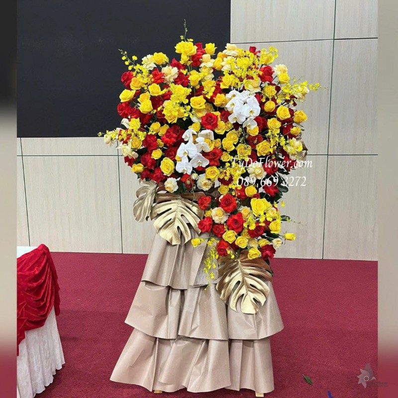 KCM0825643 KỆ HOA CHÚC MỪNG Thiết kế hoa hồng đỏ vàng, lan vũ nữ, lan hồ điệp, chân giấy mỹ thuật cao cấp