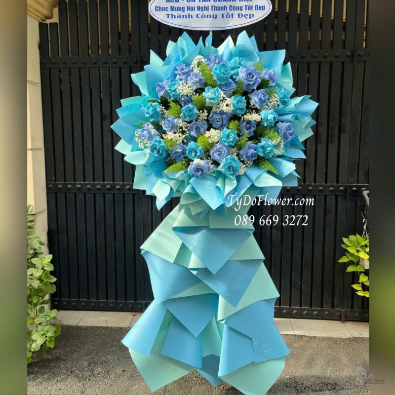 KCM1025787 KỆ HOA CHÚC MỪNG HỘI NGHỊ Thiết kế hoa hồng xanh dương trên nền giấy mỹ thuật cao cấp