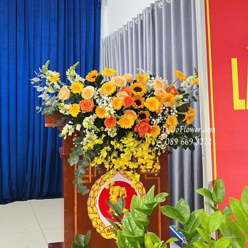 L1025863 HOA TRANG TRÍ BỤC PHÁT BIỂU Thiết kế Hoa hồng cam Spirit, hướng dương, đồng tiền, lan vũ nữ