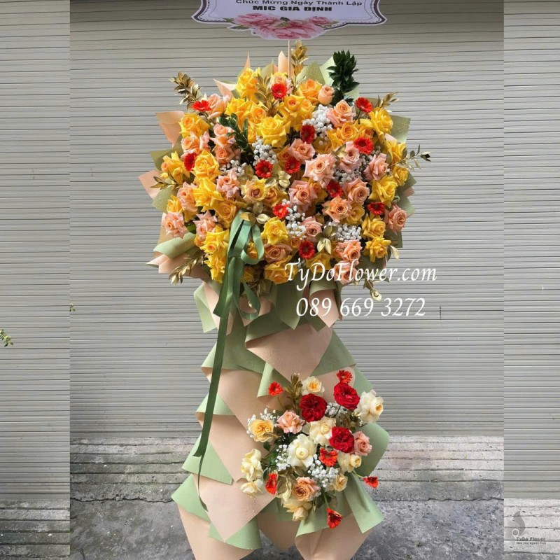 KCM0126039 KỆ HOA CHÚC MỪNG NGÀY THÀNH LẬP Thiết kế chủ đạo Hoa Hồng Vàng Cam trên nền giấy kỹ thuật cao cấp