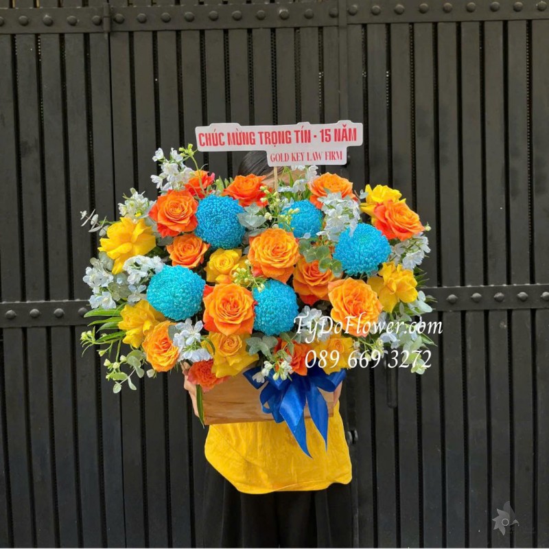 G0226106 GIỎ HOA CHÚC MỪNG 15 NĂM THÀNH LẬP Thiết kế tông màu cam xanh dương, hoa hồng vàng cam, cúc mẫu đơn xanh dương
